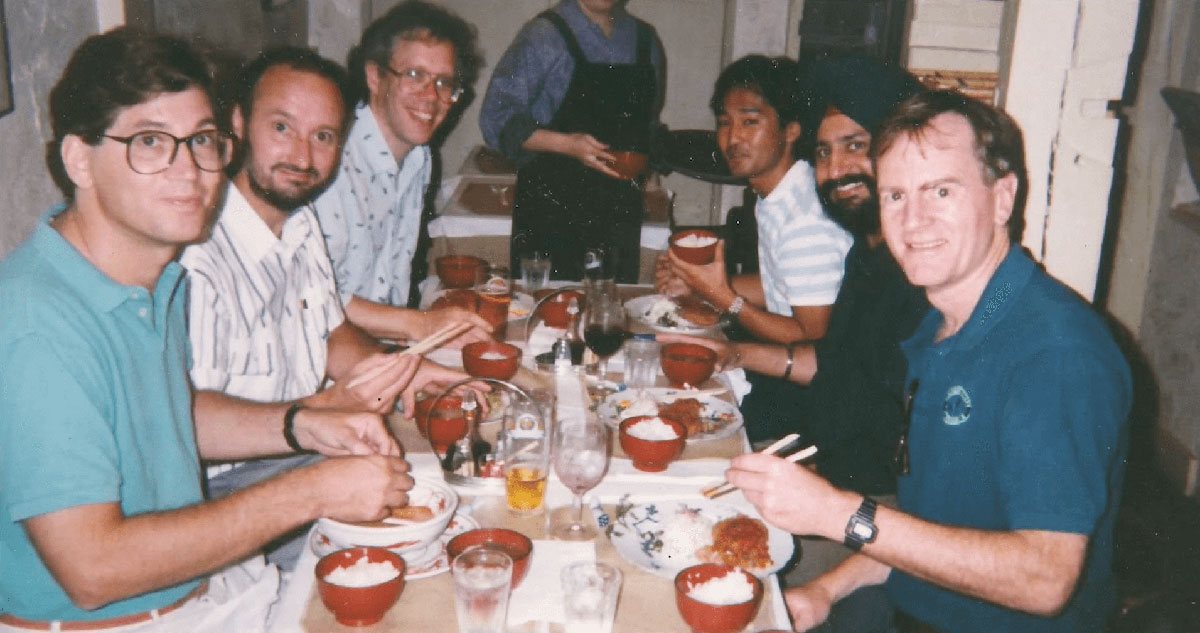 L'équipe de General Magic réunie autour d'un repas, avec Marc Porat et John Sculley visibles, symbole de la confiance qui régnait encore avant la trahison